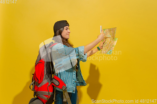 Image of Portrait of a cheerful young caucasian tourist girl isolated on yellow background