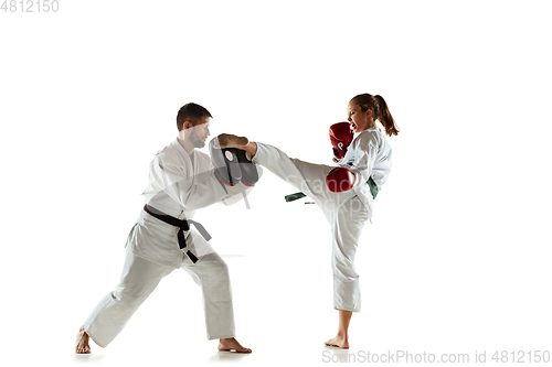 Image of Junior in kimono practicing hand-to-hand combat with coach, martial arts