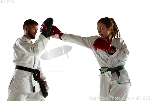 Image of Junior in kimono practicing hand-to-hand combat with coach, martial arts