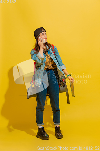 Image of Portrait of a cheerful young caucasian tourist girl isolated on yellow background