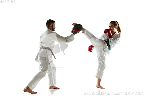 Image of Junior in kimono practicing hand-to-hand combat with coach, martial arts