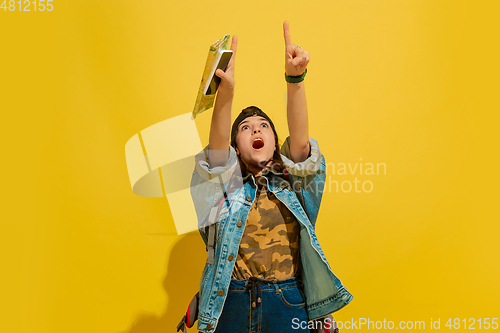 Image of Portrait of a cheerful young caucasian tourist girl isolated on yellow background