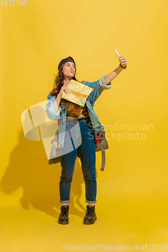 Image of Portrait of a cheerful young caucasian tourist girl isolated on yellow background