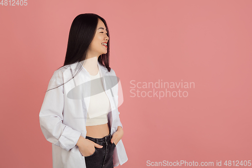 Image of Asian young woman\'s portrait on pink studio background. Concept of human emotions, facial expression, youth, sales, ad.