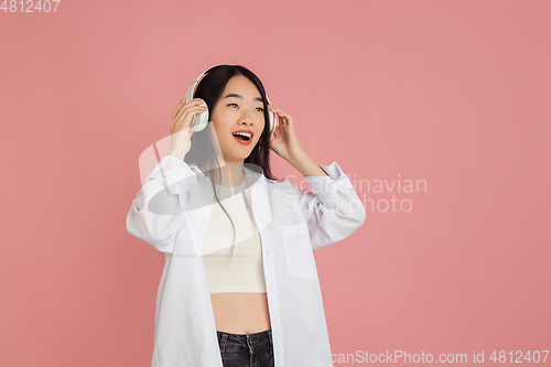 Image of Asian young woman\'s portrait on pink studio background. Concept of human emotions, facial expression, youth, sales, ad.