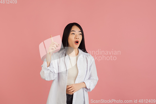 Image of Asian young woman\'s portrait on pink studio background. Concept of human emotions, facial expression, youth, sales, ad.