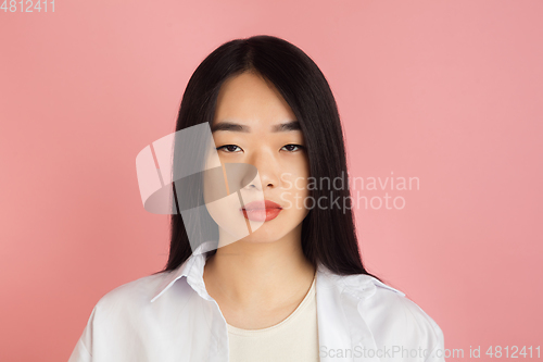 Image of Asian young woman\'s portrait on pink studio background. Concept of human emotions, facial expression, youth, sales, ad.