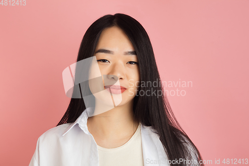 Image of Asian young woman\'s portrait on pink studio background. Concept of human emotions, facial expression, youth, sales, ad.