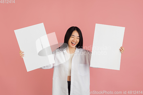 Image of Asian young woman\'s portrait on pink studio background. Concept of human emotions, facial expression, youth, sales, ad.