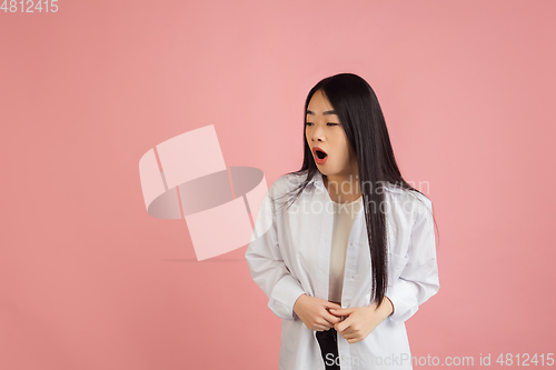 Image of Asian young woman\'s portrait on pink studio background. Concept of human emotions, facial expression, youth, sales, ad.