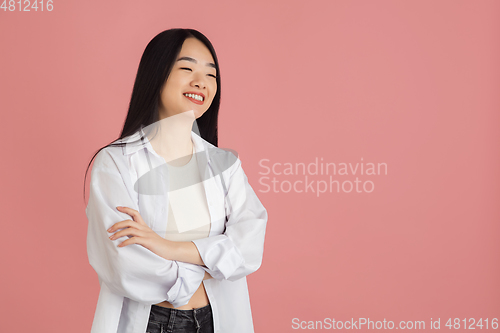 Image of Asian young woman\'s portrait on pink studio background. Concept of human emotions, facial expression, youth, sales, ad.