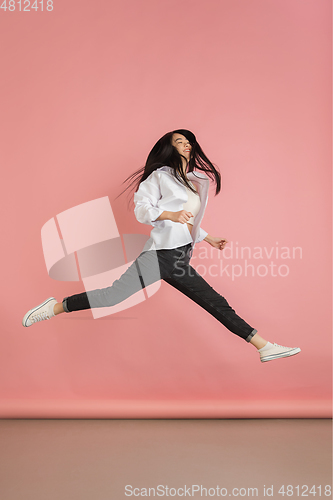 Image of Asian young woman\'s portrait on pink studio background. Concept of human emotions, facial expression, youth, sales, ad.