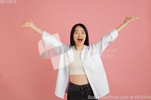 Image of Asian young woman\'s portrait on pink studio background. Concept of human emotions, facial expression, youth, sales, ad.