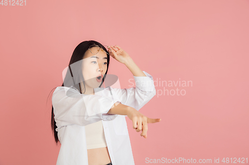 Image of Asian young woman\'s portrait on pink studio background. Concept of human emotions, facial expression, youth, sales, ad.