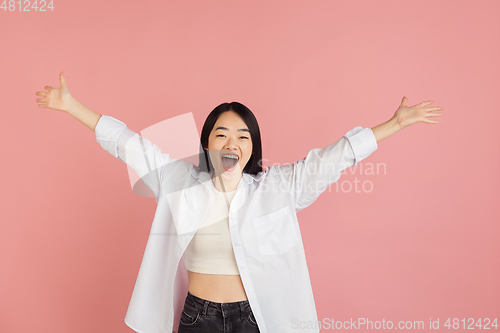 Image of Asian young woman\'s portrait on pink studio background. Concept of human emotions, facial expression, youth, sales, ad.
