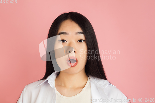 Image of Asian young woman\'s portrait on pink studio background. Concept of human emotions, facial expression, youth, sales, ad.