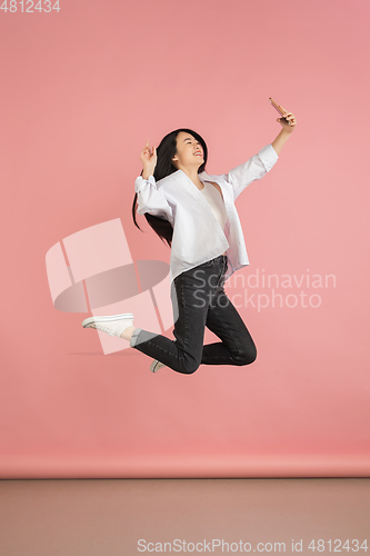 Image of Asian young woman\'s portrait on pink studio background. Concept of human emotions, facial expression, youth, sales, ad.
