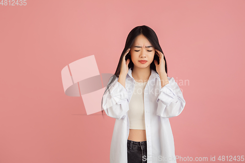 Image of Asian young woman\'s portrait on pink studio background. Concept of human emotions, facial expression, youth, sales, ad.