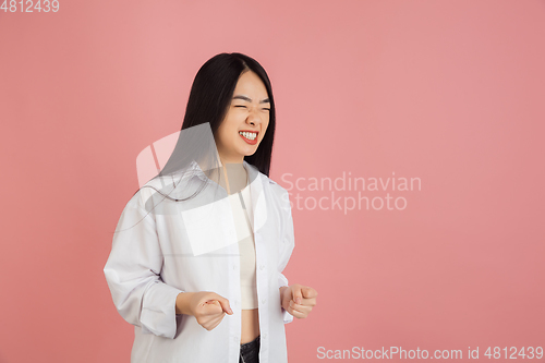 Image of Asian young woman\'s portrait on pink studio background. Concept of human emotions, facial expression, youth, sales, ad.