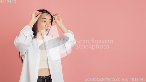 Image of Asian young woman\'s portrait on pink studio background. Concept of human emotions, facial expression, youth, sales, ad.