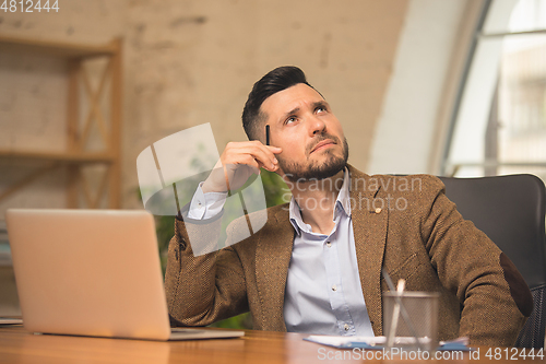 Image of Man working in modern office using devices and gadgets during creative meeting.