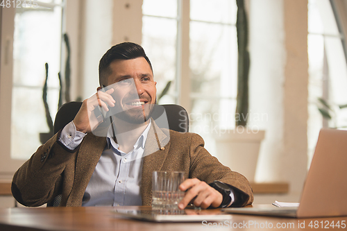 Image of Man working in modern office using devices and gadgets during creative meeting.