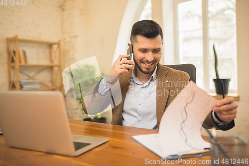Image of Man working in modern office using devices and gadgets during creative meeting.