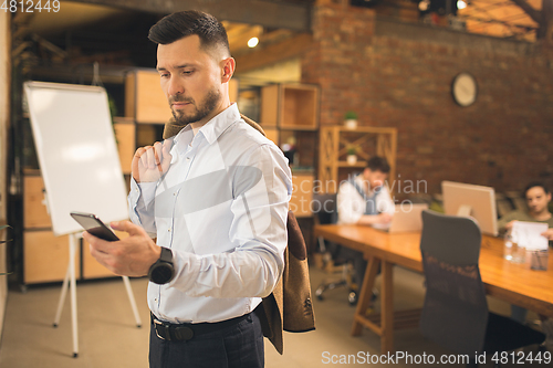 Image of Man working in modern office using devices and gadgets during creative meeting.