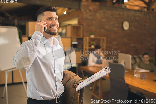 Image of Man working in modern office using devices and gadgets during creative meeting.