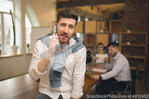 Image of Man working in modern office using devices and gadgets during creative meeting.