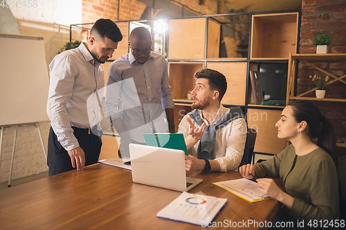 Image of Colleagues working together in modern office using devices and gadgets during creative meeting