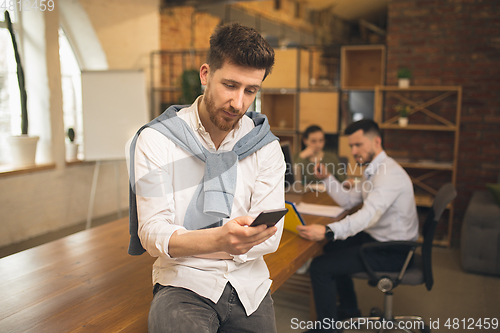 Image of Man working in modern office using devices and gadgets during creative meeting.