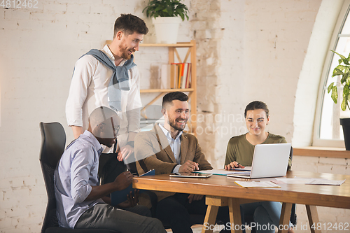 Image of Colleagues working together in modern office using devices and gadgets during creative meeting