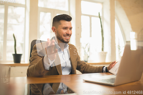 Image of Man working in modern office using devices and gadgets during creative meeting.