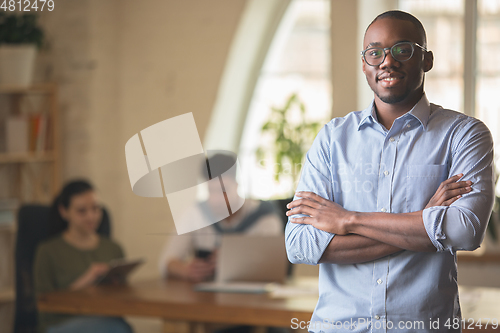 Image of Man working in modern office using devices and gadgets during creative meeting.