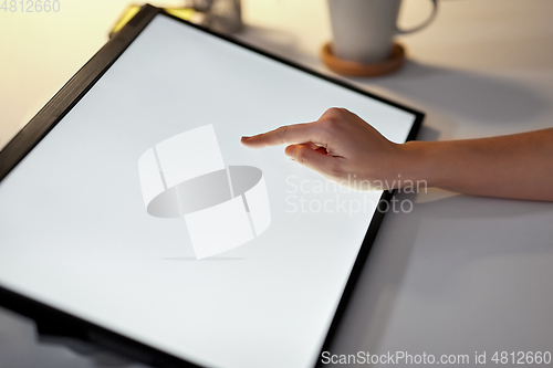 Image of hand on led light tablet at night office