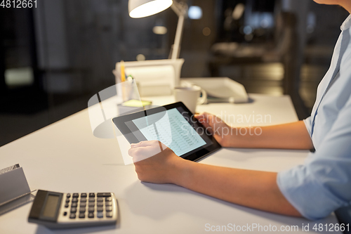 Image of businesswoman with tablet computer at night office