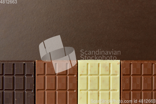 Image of different kinds of chocolate on brown background