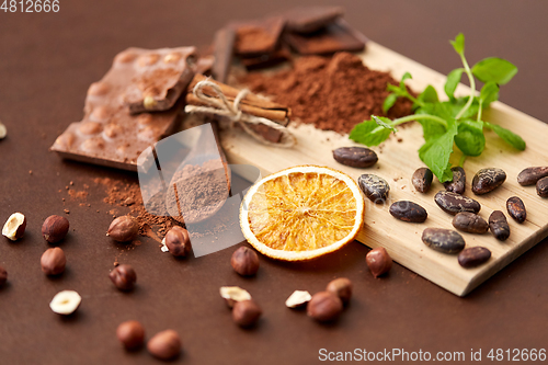 Image of chocolate with hazelnuts, cocoa beans and orange