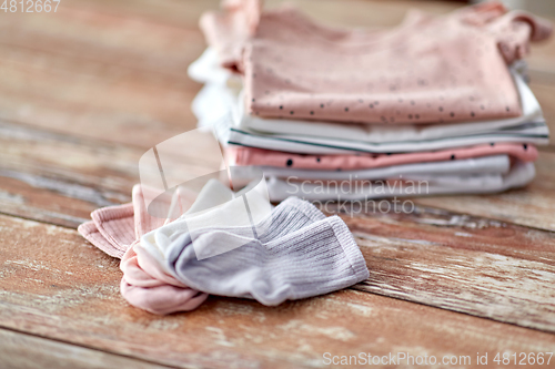 Image of close up of baby clothes on wooden table