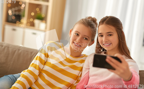 Image of happy girls taking selfie with smartphone at home