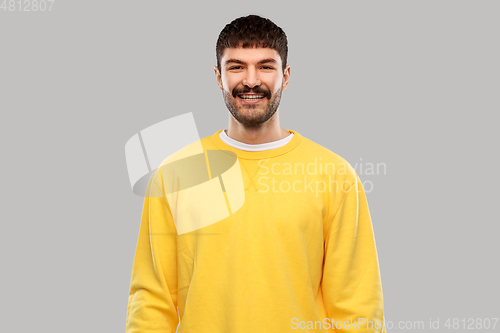 Image of smiling young man in yellow sweatshirt