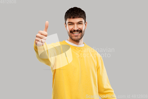Image of smiling young man showing thumbs up