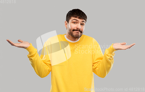 Image of confused man in yellow sweatshirt shrugging