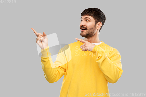 Image of smiling man pointing fingers to something