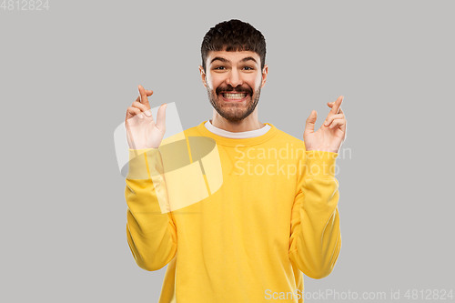 Image of smiling man with crossed fingers