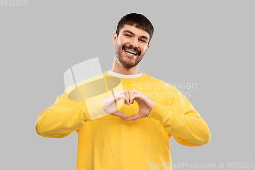 Image of smiling young man in yellow sweatshirt