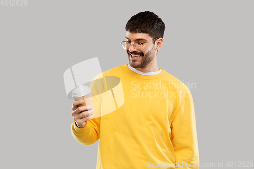 Image of smiling young man with takeaway coffee cup
