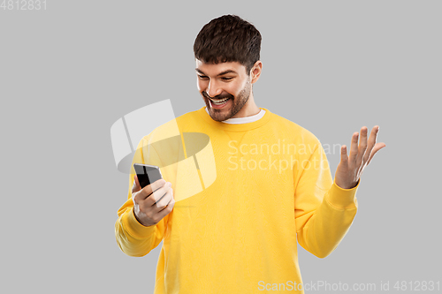 Image of happy smiling young man with smartphone