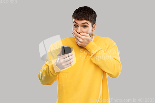 Image of shocked young man with smartphone